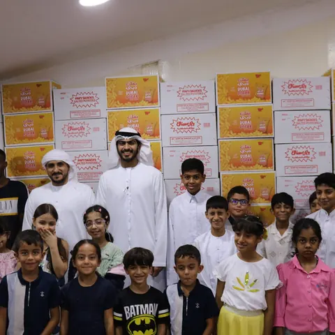Children and staff in front of stacked Modernfood cartons