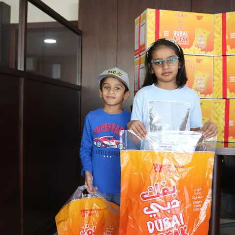 Two children holding bags of Dubai Pofak
